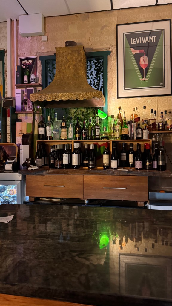 Lots of bottles and a vintage rangehood set the mood in the bar at Le Vivant.